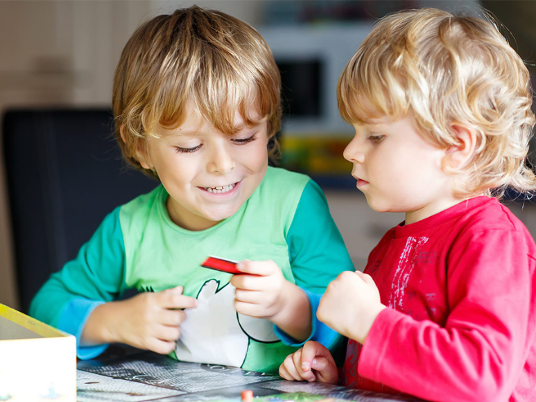 two kids playing with a game